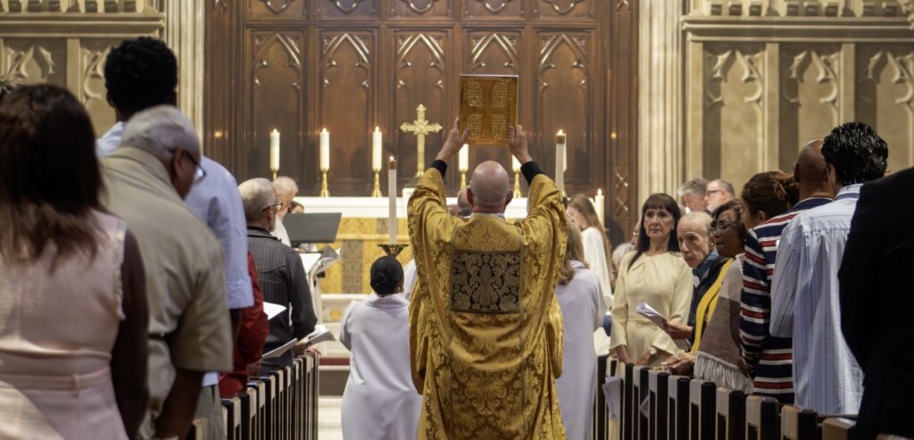 Clergy carrying the Gospel through the congregation during worship at St. James’.