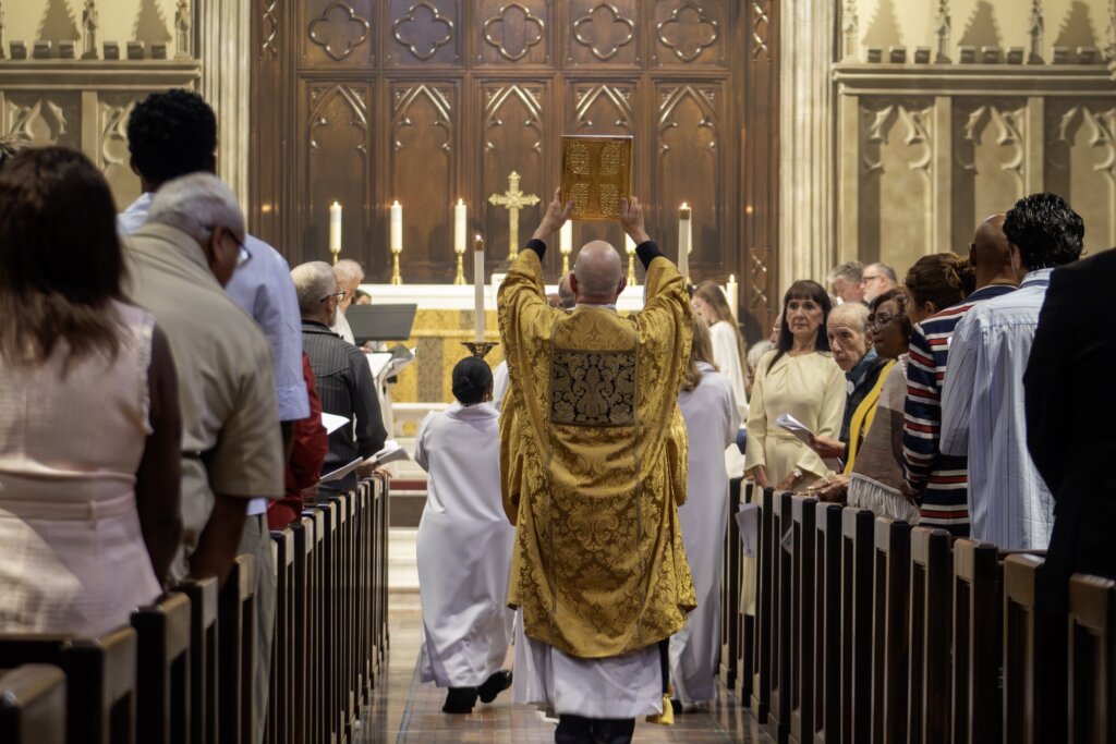 Clergy carrying the Gospel through the congregation during worship at St. James’.